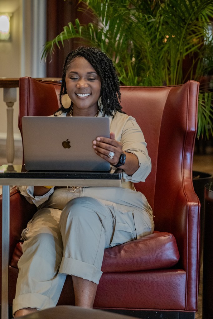 Dawn sitting in from of her laptop in a high-back chair