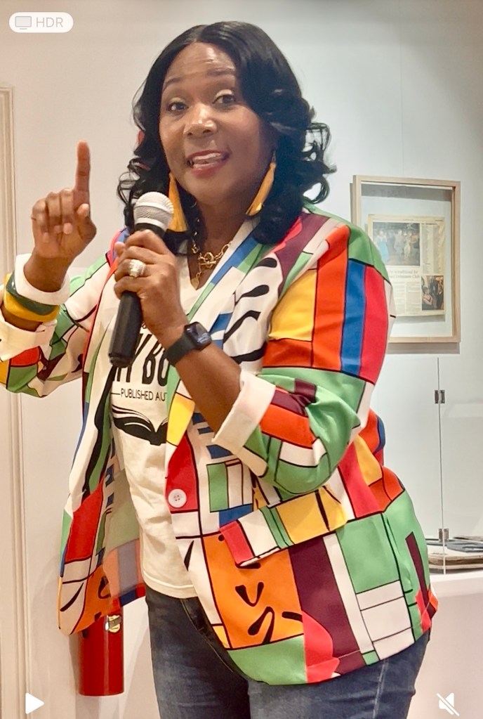 Dawn speaking to a group of women pointing her finger while making a point