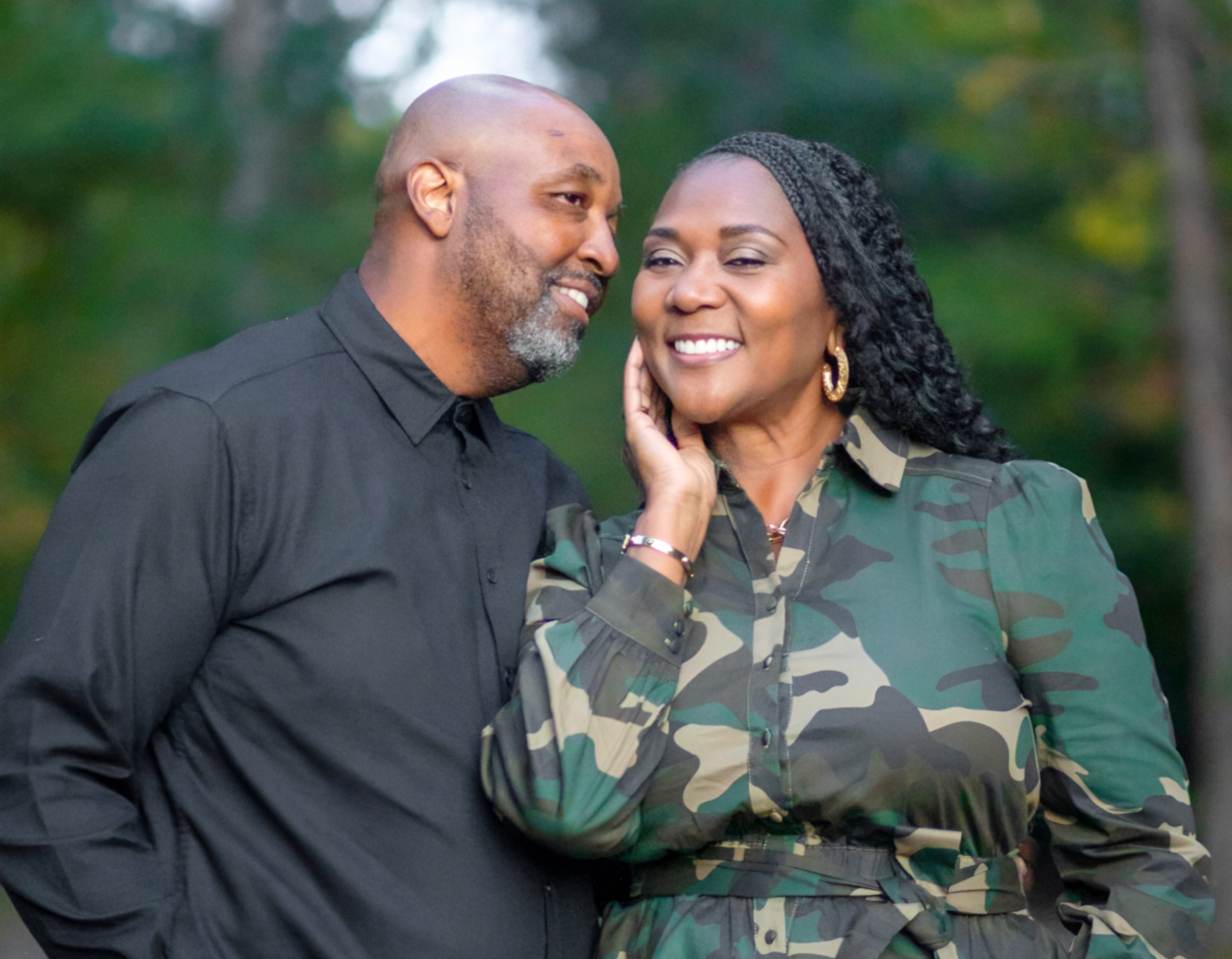 Dawn and Leon Green wearing camouflage with Leon whispering into Dawn's er.