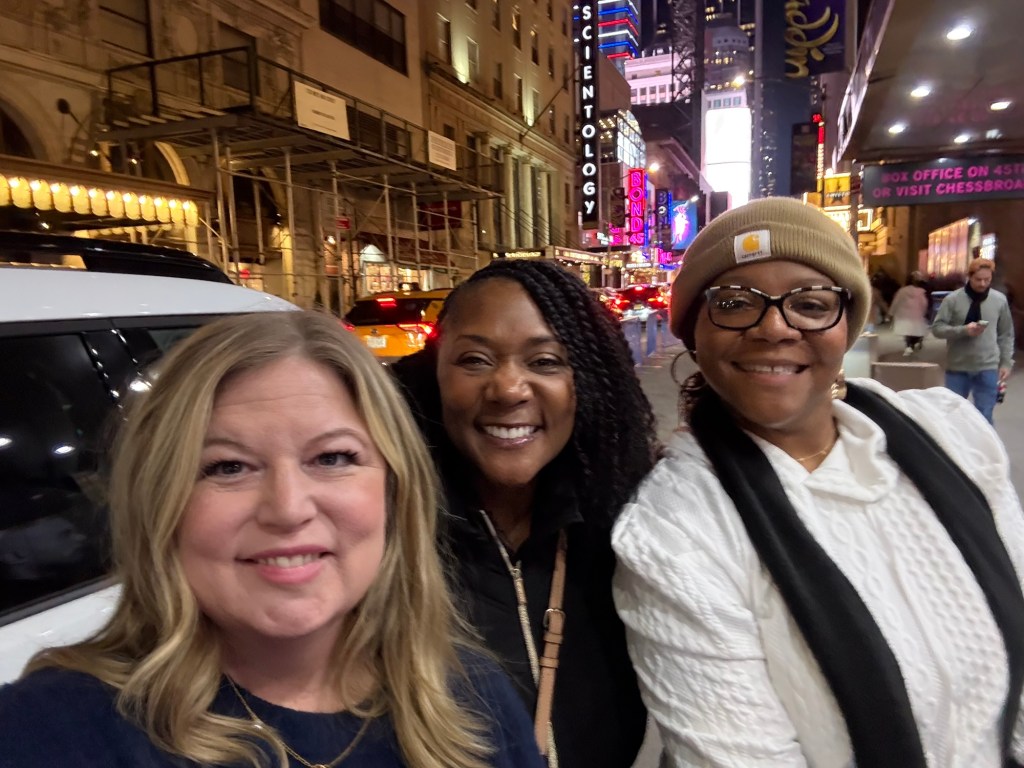Dawn Charleston-Green standing in from the Hamilton Theater between friends Michelle Black (left) and Tanya Whatley (right)