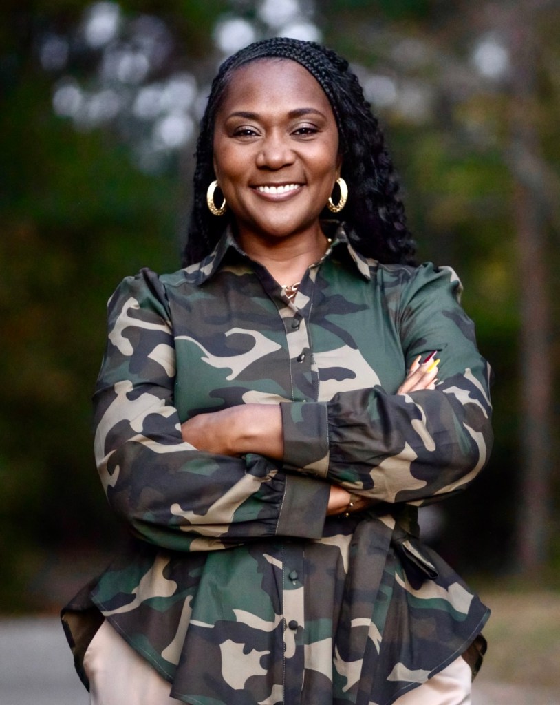 Dawn Charleston-Green standing with arms folded wearing a camouflage jacket